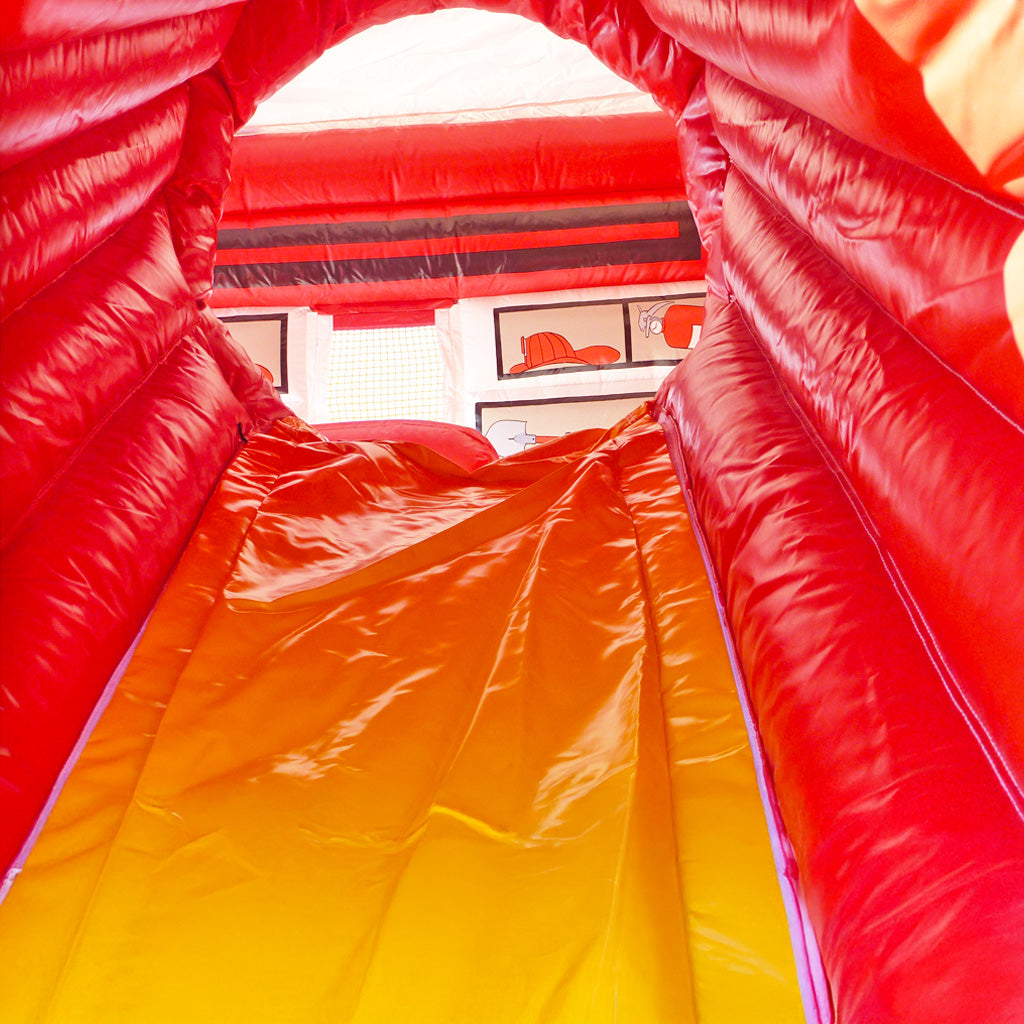 Eine rot-gelbe Rutsche von einer Hüpfburg.