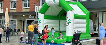 Aufblasbare Hüpfburg mit Logos steht auf einer Straße, Kinder hüpfen auf der Hüpfburg.Individuelle Hüpfburg Sonderanfertigung - jetzt anfertigen lassen Aufblasbare Hüpfburg mit Logos steht auf einer Straße, Kinder hüpfen auf der Hüpfburg.Individuelle Hüpfburg Sonderanfertigung - jetzt anfertigen lassen