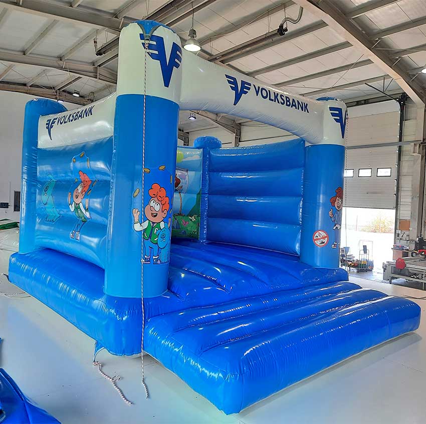 Aufblasbare Hüpfburg mit Figuren an den Säulen in einer Halle