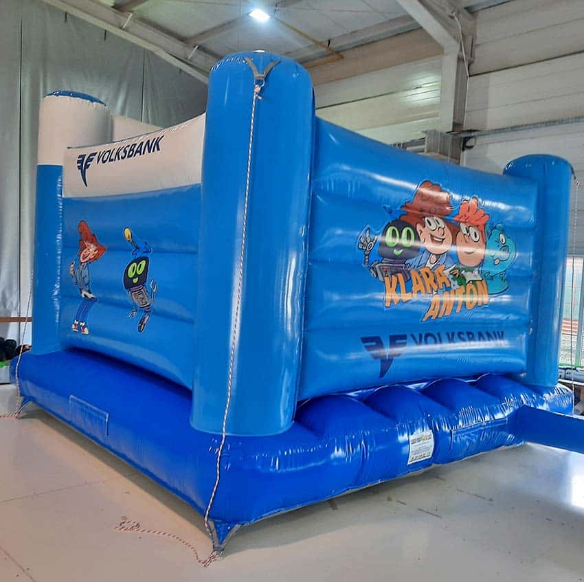 Farbenfrohe Hüpfburg mit Figuren an den Wänden von hinten