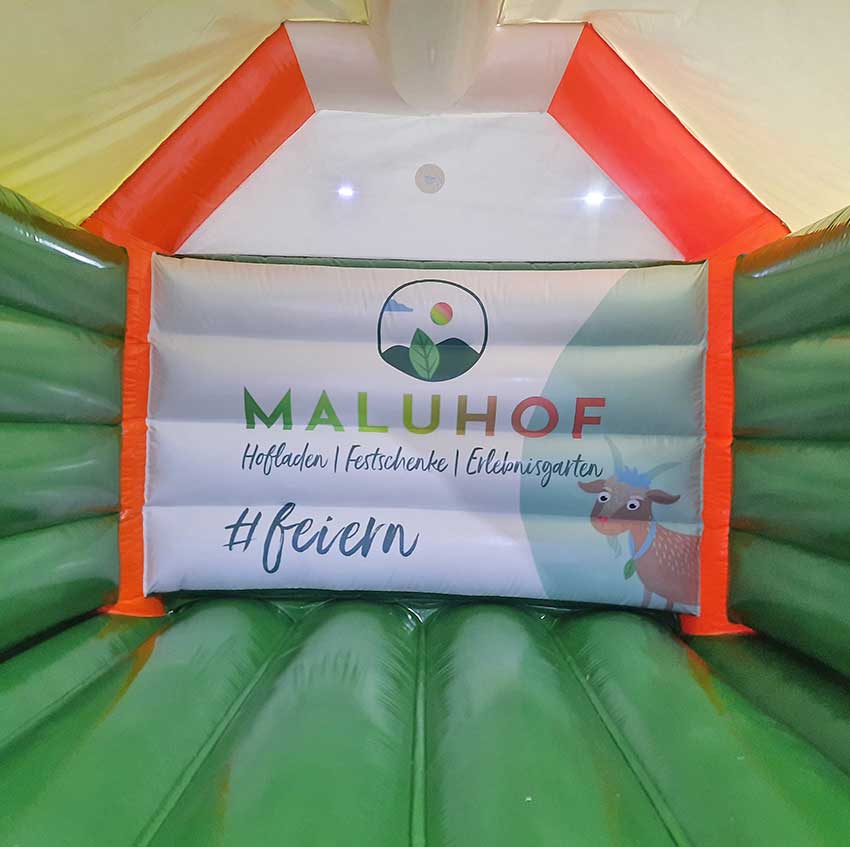 Hüpfburg von Innen mit einem Logo auf der Rückwand