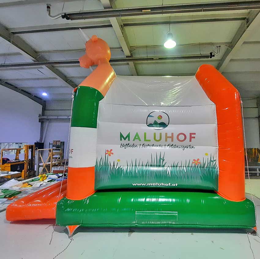 Farbenfrohe Hüpfburg von der Seite in einer Halle