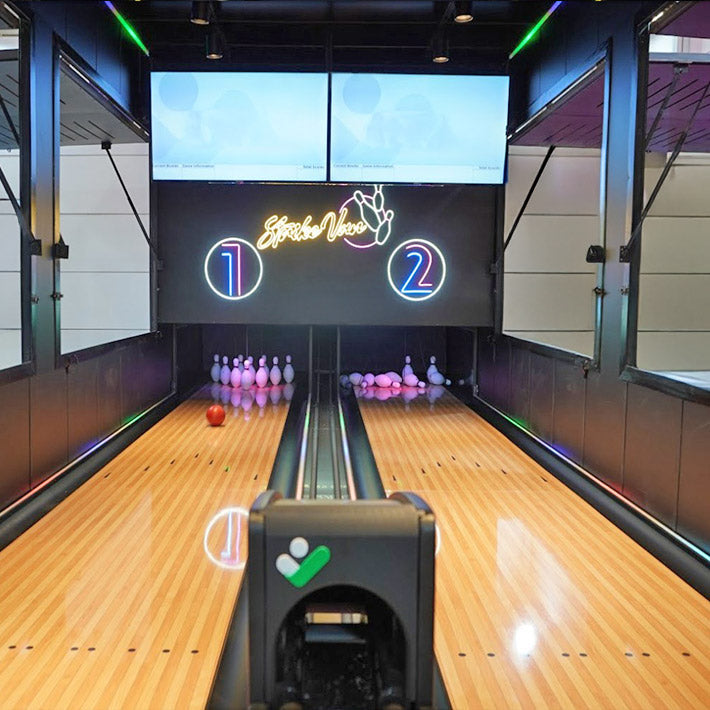 Bowling Anlage mit stehenden und umgefallenen Kegeln.