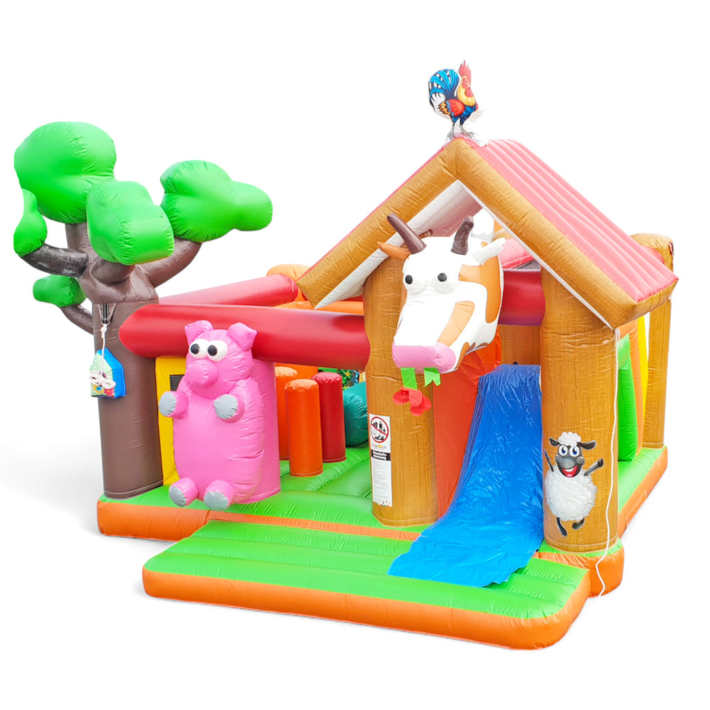 Eine Hüpfburg mit einer Kuh einem Schwein sowie mit Hindernissen und einer Rutsche.