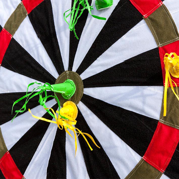 Pfeile in Gruen und Gelb haften mit Klett auf einem Riesendart.