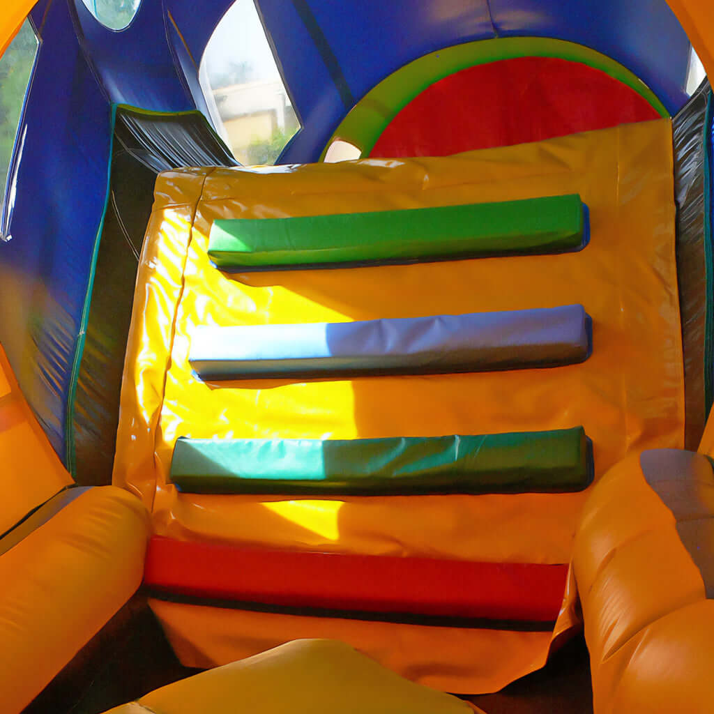 Innenansicht mit bunter Kletterwand in einer aufblasbaren Eisenbahn-Hüpfburg - perfekt für aktive Kinder und spannende Abenteuer im Zug.