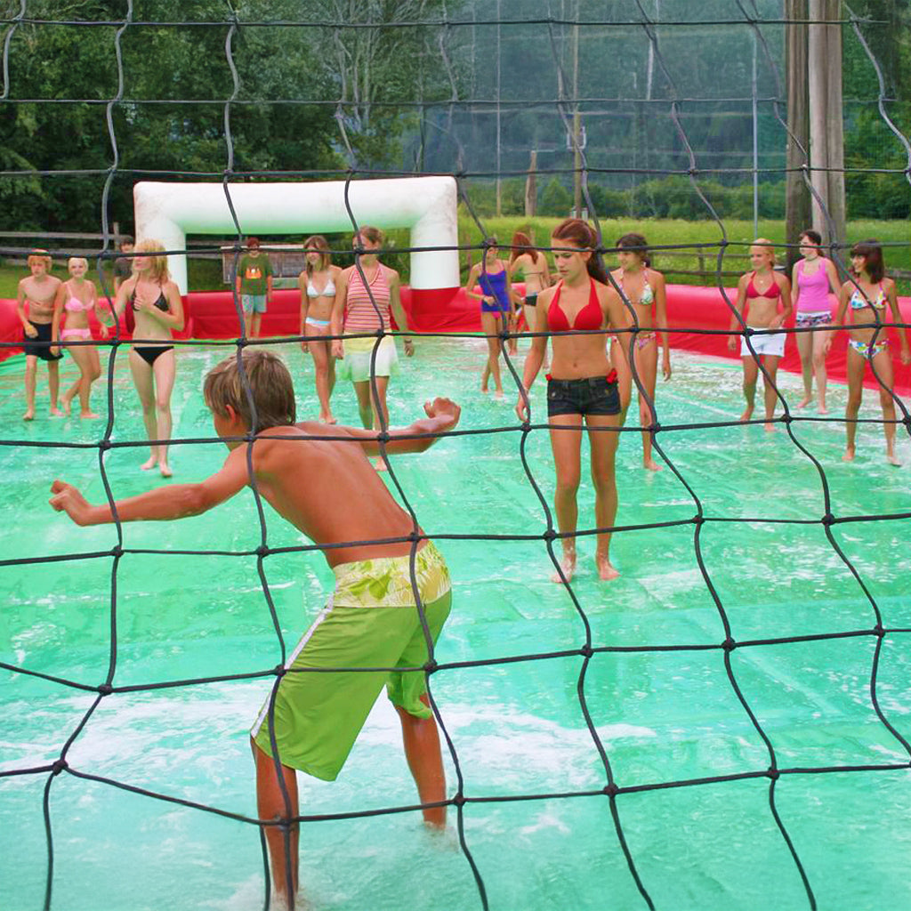 Viele Kinder beim Fußball spielen in einem Soap Soccer ohne aufblasbaren Boden.