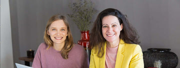 Zwei Frauen lächeln in einem modernen Beratungsraum bei einem persönlichen Gespräch