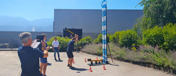 Ein Mann schlägt mit einen großen Gummihammer auf einem Hau den Lukas.