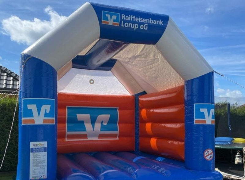Eine Hüpfburg mit Raiffeisenbank Logo.Hüpfburg Shop – Profi Hüpfburgen | Viele Modelle auf Lager ✓