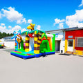 Farbenfrohe Dschungel Huepfburg mit Rutsche auf einem Betonplatz