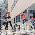 People play XXL chess with large chess pieces outdoors