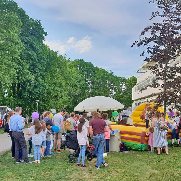 Mehrere Personen bei einem Rodeo Simulator auf einem Fest.