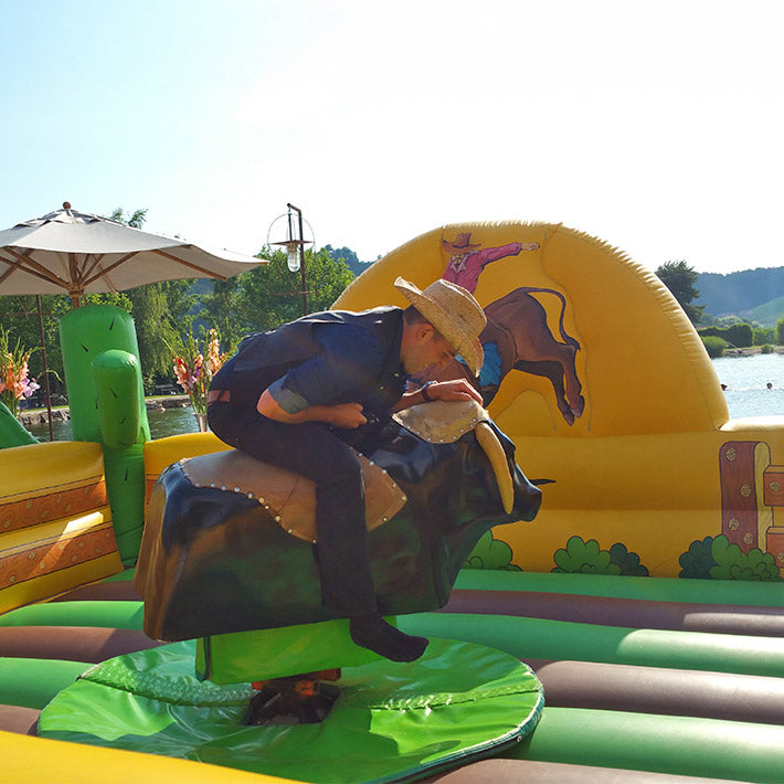 Ein Mann reitet auf einen Rodeo Simulator. 