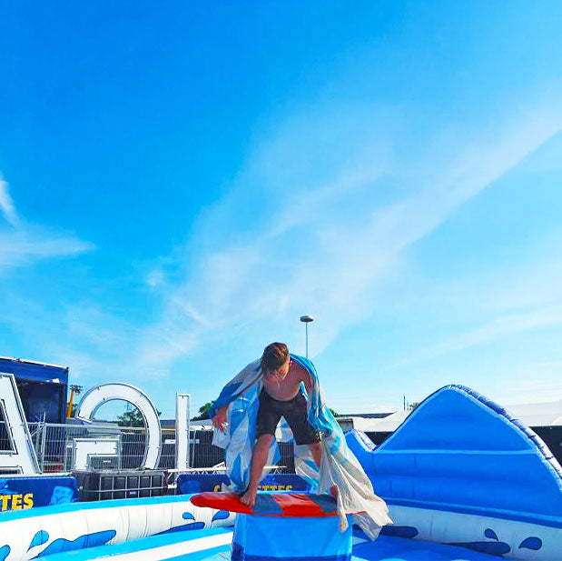Ein Kind das auf einem aufblasbarem Surf Rodeo im Freien steht 