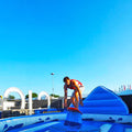 Junger Mann der auf einem aufblasbarem Surf Simulator im Freien steht