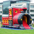 Bouncy castle locomotive stands on a green meadow.