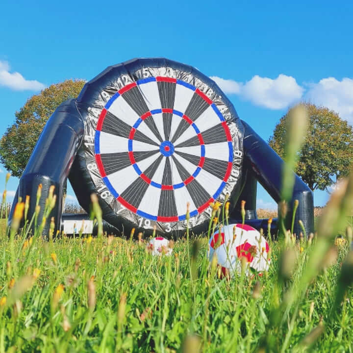 Kinder und Erwachsene schießen Bälle mit Klettfläche auf eine große Dartscheibe und zielen auf möglichst hohe Punktzahlen – eine spaßige Kombination aus Fußball und Geschicklichkeitsspiel