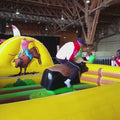 Mehrere Personen, Kinder, Erwachsene  reiten auf einen Rodeo Bullen Simulator.
