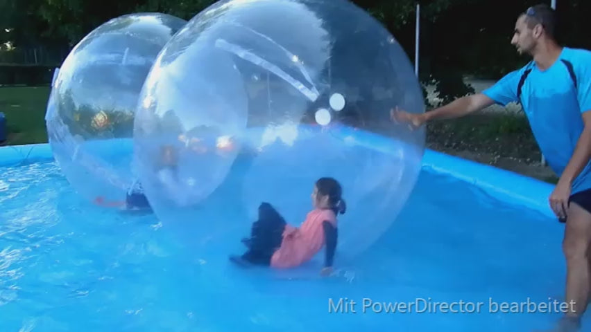 Kinder in aufblasbaren Baellen in einem aufblasbarem Becken mit Wasser. 