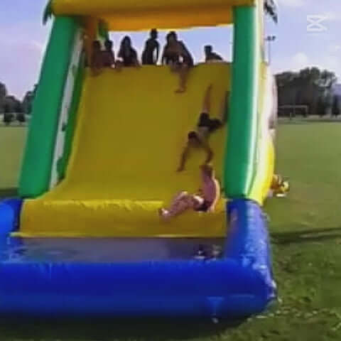 Video von Kinder die eine Wasserrutsche mit Auffangbecken runter rutschen und Spass dabei haben. 