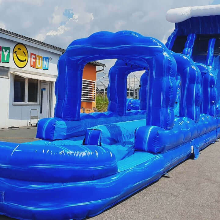 Kinder und Jugendliche rutschen mit Schwung eine lange, bunte Wasserrutsche hinab und landen im erfrischenden Wasserbecken – perfekter Sommerspaß für Groß und Klein.